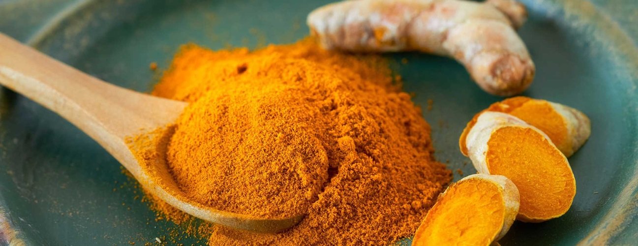 Turmeric powder and fresh turmeric root showcasing turmeric benefits for skin health.